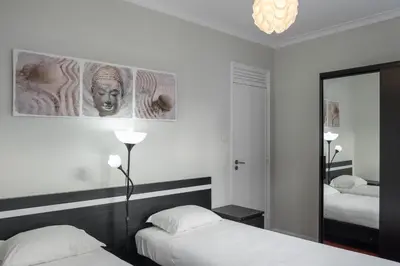 a white room with two beds and a mirror at Apartamentos Portodouro - Ribeira in Porto