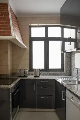 a kitchen with black cabinets and a window at Apartamentos Portodouro - Ribeira in Porto