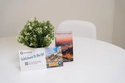 a plant in a vase next to a book at GuestReady - Sunny Stay in Porto City Center in Porto