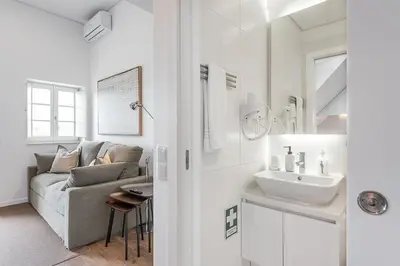 a white living room with a couch and a sink at GuestReady - Riverview Douro Terrace in Vila Nova de Gaia