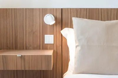 a bed with a night stand next to a bed with a pillow at GuestReady - Riverview Douro Terrace in Vila Nova de Gaia
