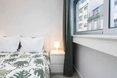 a bedroom with a bed and a window at Moreira Family in Porto