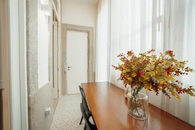 a vase of flowers on a table in a room at Home With a Pool by Vacationy in Porto