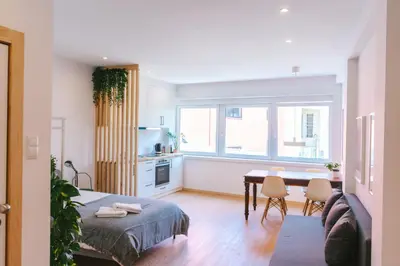 a living room with a table and a kitchen at Porto serenity studio in Porto