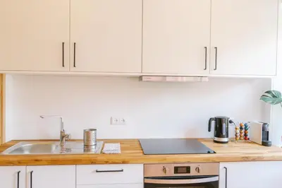 a kitchen with white cabinets and a sink at Porto serenity studio in Porto
