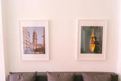 two framed pictures on a white wall above a couch at Porto serenity studio in Porto