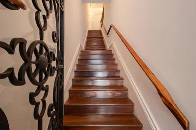 a stairway with a wooden rail and wooden stairs with wood floors at Clerigos 82 luxury Housing in Porto