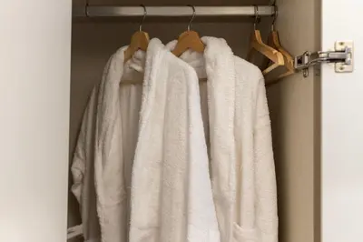 a group of white towels hanging on a rack at BmyGuest Collection - The Marquis Luxury Garden Apartment in Porto