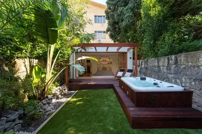a garden with a bath tub in a yard at BmyGuest Collection - The Marquis Luxury Garden Apartment in Porto