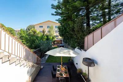 a table with an umbrella on a wooden deck at BmyGuest Collection - The Marquis Luxury Garden Apartment in Porto
