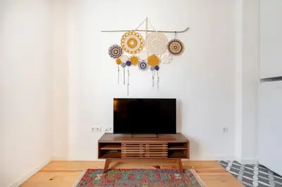 a living room with a flat screen tv on a table at VIVA Bonfim Cozy Home in Porto