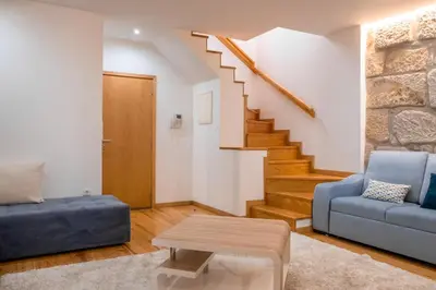 a living room with a blue couch and stairs at Casa do Vasco in Porto