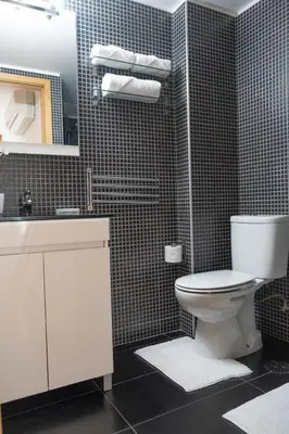 a bathroom with a toilet and a sink and a mirror at Casa do Vasco in Porto