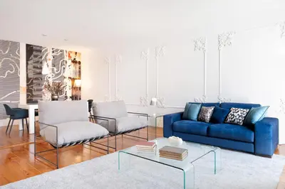 a living room with a blue couch and chairs at Historical Penthouse at Cardosas Block in Porto
