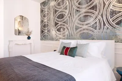 a bedroom with a white bed with a wall mural at Historical Penthouse at Cardosas Block in Porto