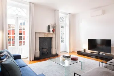 a living room with a blue couch and a fireplace at Historical Penthouse at Cardosas Block in Porto
