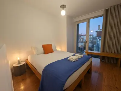a bedroom with a bed and a large window at Panorama Apartments Porto Poveiros in Porto