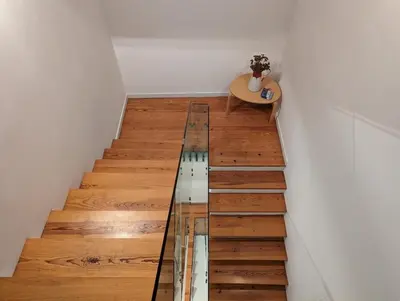 a glass staircase with a table and a wooden floor at Panorama Apartments Porto Poveiros in Porto