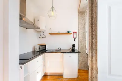 a small kitchen with white cabinets and a microwave at Panorama Apartments Porto Poveiros in Porto