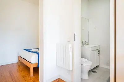 a white bathroom with a toilet and a sink at Panorama Apartments Porto Poveiros in Porto