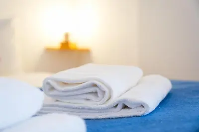 a pile of towels sitting on top of a bed at Panorama Apartments Porto Poveiros in Porto