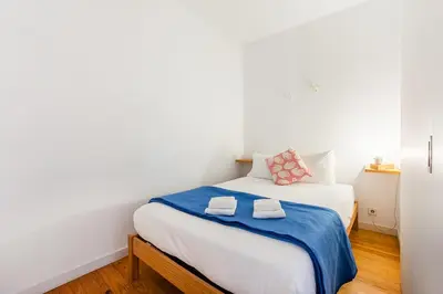 a bedroom with a white bed with two towels on it at Panorama Apartments Porto Poveiros in Porto