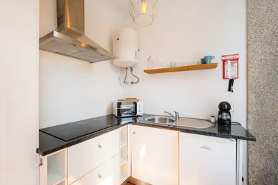 a kitchen with white cabinets and a sink at Panorama Apartments Porto Poveiros in Porto