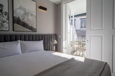 a bedroom with a bed and a door to a balcony at Limehome Porto Rua de Dom Manuel II in Porto