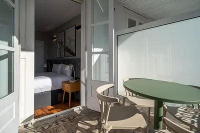 a room with a table and chairs and a bed at Limehome Porto Rua de Dom Manuel II in Porto