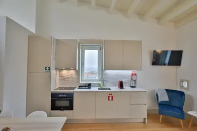 a kitchen with white cabinets and a window at Mártires Sweet Apts by PortoCityHosts in Porto