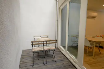 a room with a table and chairs in a room with a window at Mártires Sweet Apts by PortoCityHosts in Porto