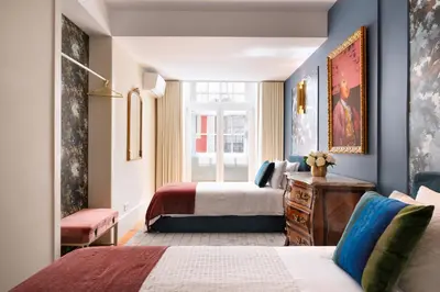 a hotel room with two beds and a window at Cardosas Gem - Historic ap 1F in Porto