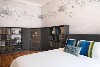 a bedroom with a bed and bookshelves at Cardosas Gem - Historic ap 1F in Porto