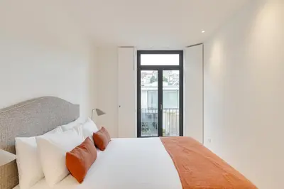 a white bedroom with a bed and a window at Alma da Casa by DA'HOME in Porto