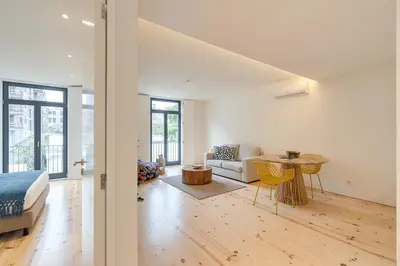 a bedroom with a bed and a living room with a table at Alma da Casa by DA'HOME in Porto