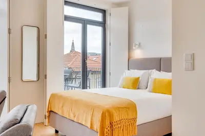 a bedroom with a bed and a large window at Alma da Casa by DA'HOME in Porto