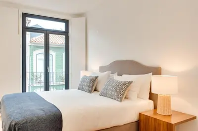 a bedroom with a white bed with pillows and a window at Alma da Casa by DA'HOME in Porto