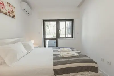 a white bedroom with a bed with two towels on it at Pateo In Lapa City Center by Vacationy in Porto