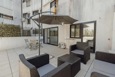 a patio with two chairs and an umbrella at Pateo In Lapa City Center by Vacationy in Porto