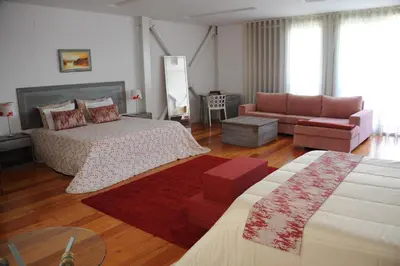 a bedroom with a bed and a couch and a table at Capim Dourado Apartments Cedofeita in Porto