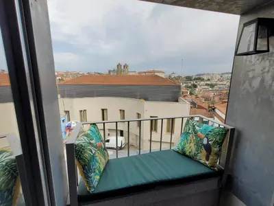 a balcony with a bench with a view of a city at GuestReady - Elegant living in Porto city centre in Porto