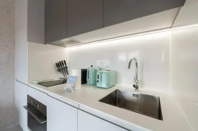 a kitchen with white cabinets and a sink at GuestReady - Elegant living in Porto city centre in Porto