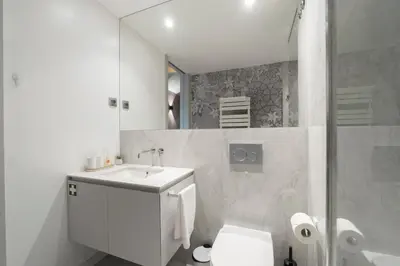 a bathroom with a sink and a toilet and a mirror at GuestReady - Elegant living in Porto city centre in Porto