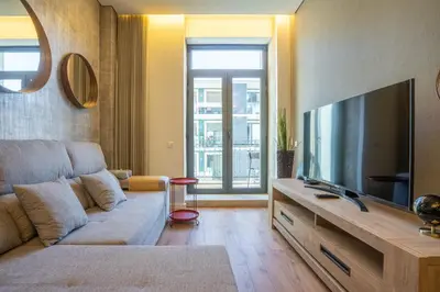 a living room with a couch and a flat screen tv at João IV Jewel Retreat by LovelyStay in Porto