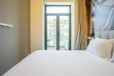 a bedroom with a large bed and a large window at João IV Jewel Retreat by LovelyStay in Porto