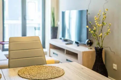 a room with a table with a television and a chair at João IV Jewel Retreat by LovelyStay in Porto