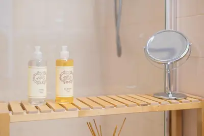 two bottles on a wooden shelf with a mirror at Santo António Loft - Porto Perfect in Porto