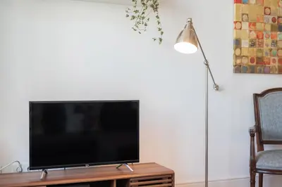 a flat screen tv sitting on a table next to a lamp at Santo António Loft - Porto Perfect in Porto