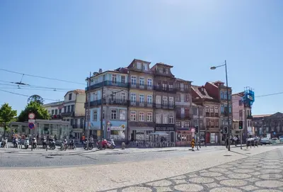a large building on a city street with people on bikes at Hungarian Biscuits Historic Center in Porto