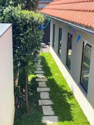 a garden with a stone path between two buildings at JM Alojamento local no Porto in Porto
